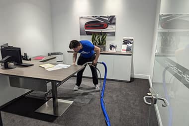 Cronos cleaning an office workspace